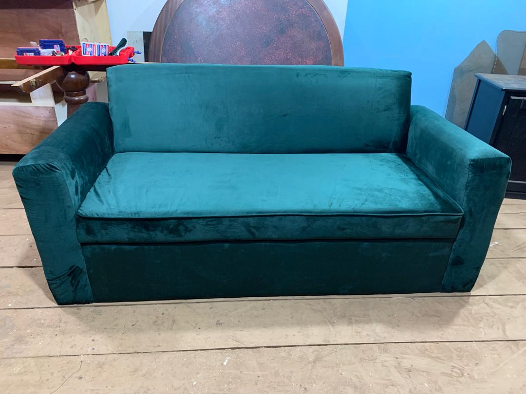 Canapé en bois massif garni de velours turquoise, à l'atelier DKBOIS