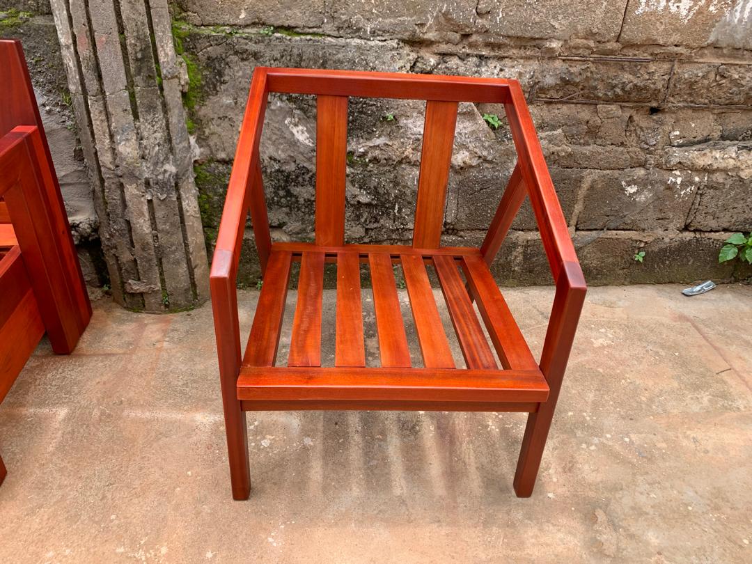 Fauteuil en bois massif teinté rouge, assise et dossier à lattes, sorti de l'atelier DKBOIS